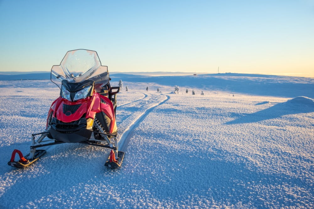 Snoscooter i vinterlandskap. Foto